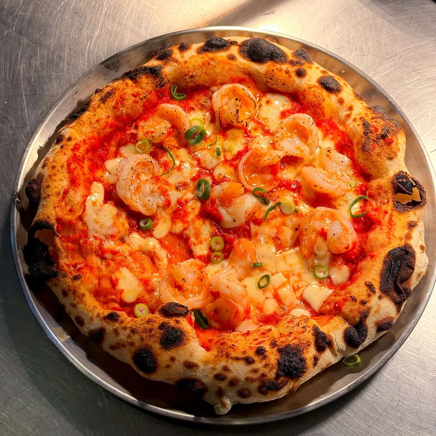 Chilli gamberi pizza straight from the wood fire: prawns, chilli and fior di latte on a blistered crust